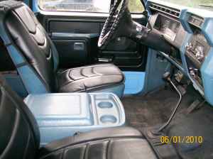 1981 Ford Bronco - The interior of a 1980s Ford Bronco shows blue plastic trim and black vinyl seats.