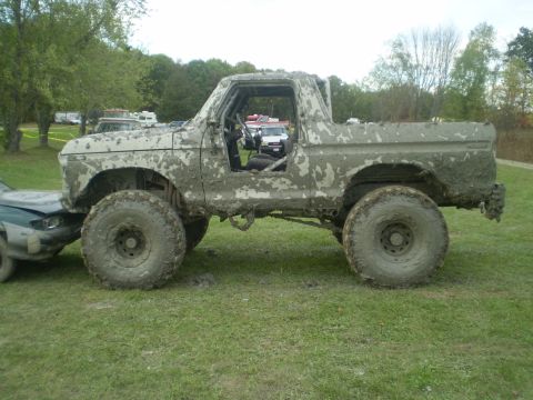 1979 Ford Bronco - This heavily mud-splattered SUV, likely a 1978 Ford Bronco, is being towed by a car.