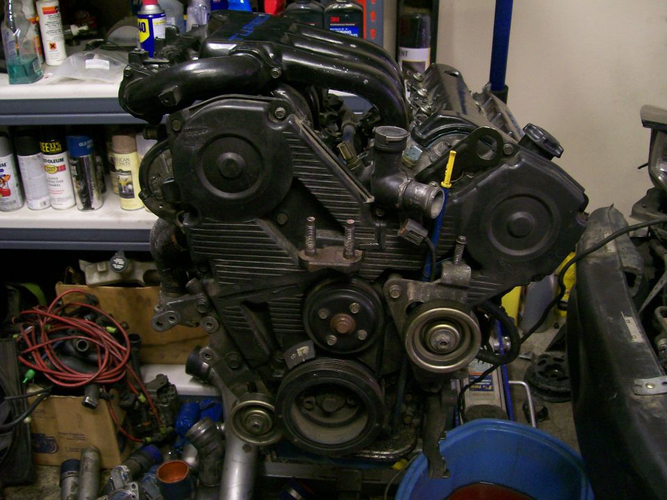 Black engine with black intake manifold and black timing belt covers, seen from the front-right