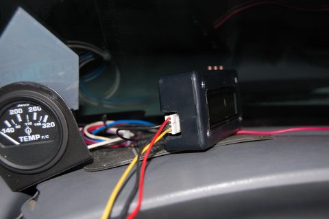1994 Ford Bronco - A Faria temperature gauge reading 140-320 F/C sits in a black pod on the gray dash pad, beside a second black gauge or display module still…