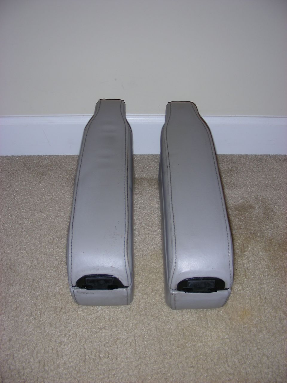 pair of gray armrests with black plastic end caps