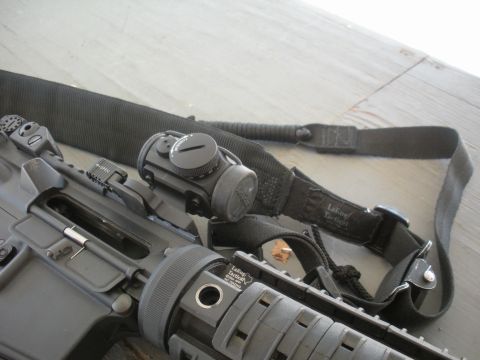 1996 Ford Bronco - Close-up of a rifle's receiver, optic, and sling, with a watermark for SuperMotors.net visible.