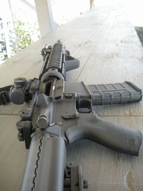 1996 Ford Bronco - AR-15 style rifle with a loaded magazine is placed on a wooden table.