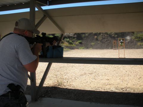 1996 Ford Bronco - A shooter takes aim at a target downrange from a covered shooting bench.