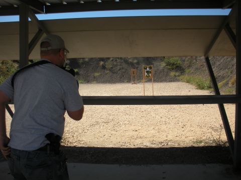 1996 Ford Bronco - A man stands at an outdoor shooting range, aiming at targets downrange.