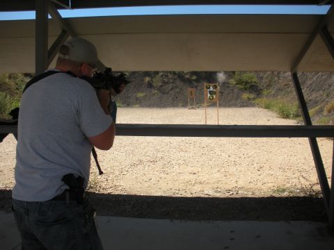 1996 Ford Bronco - Man firing a rifle at a shooting range with targets in the distance.