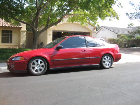 1993 Honda Civic - A red 1993 Honda Civic coupe is parked on a residential street in front of a house with an open garage.