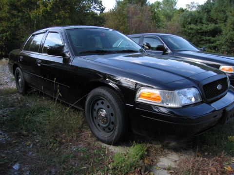 1991 Ford LTD Crown Victoria - Two black Ford Crown Victoria sedans are parked outdoors on a sunny day.