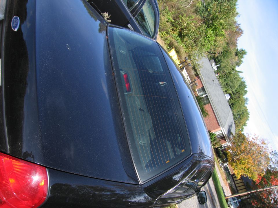 Black sedan rear, parked next to another car