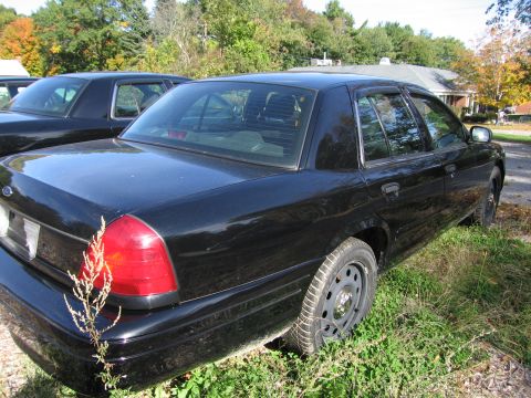 1991 Ford LTD Crown Victoria - A black 1991 Ford Crown Victoria LTD is parked next to another similar vehicle.