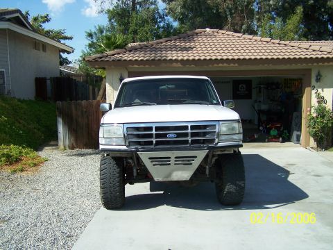 1995 Ford Bronco - A white Ford Bronco is parked in a driveway in front of a garage.