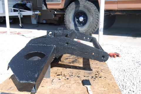 1982 Ford Bronco - A black painted metal part rests on wood with a brush and drips nearby.