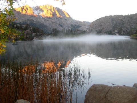 1996 Ford Bronco - A lake scene at sunrise, with mist rising from the water and golden light illuminating the mountains.
