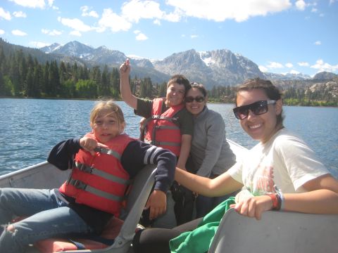 1996 Ford Bronco - A family enjoys a sunny day on the water, with snow-capped mountains in the distance.