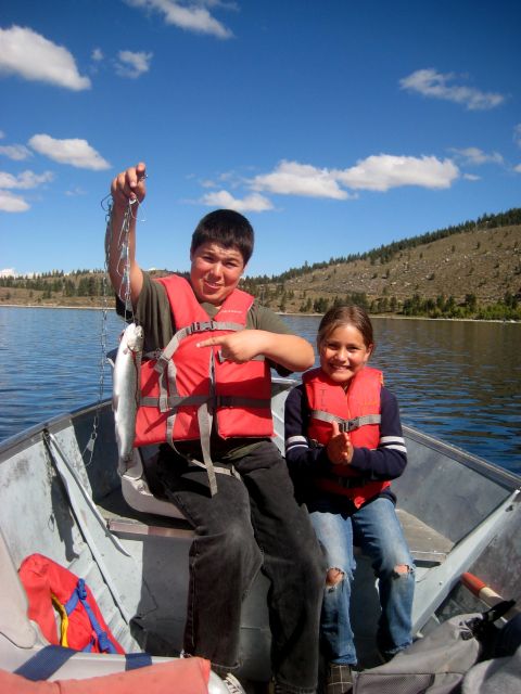 1996 Ford Bronco - Two kids enjoy a day of fishing on the lake, holding up their catch.