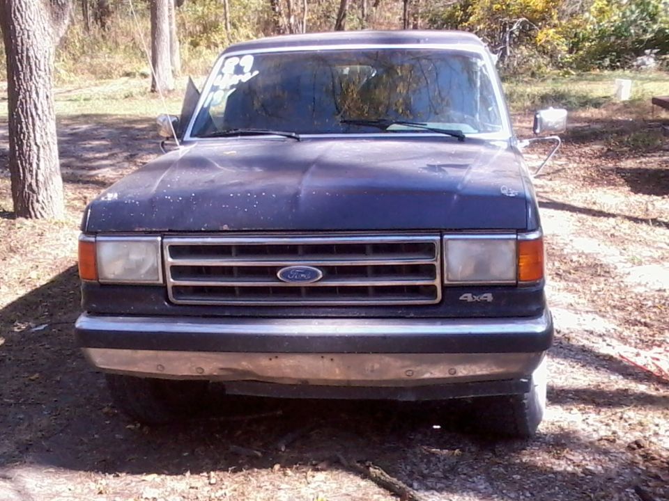 Front view of a dark blue 1989 Ford Bronco with a chrome bumper and grille