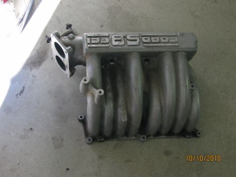 1994 Ford Bronco - Ford 5.0L HO intake manifold shown on a concrete surface.