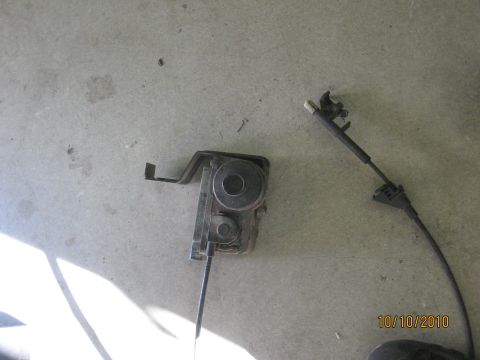 1994 Ford Bronco - This image shows a detached throttle cable and actuator mechanism, likely removed from a vehicle for repair or replacement.