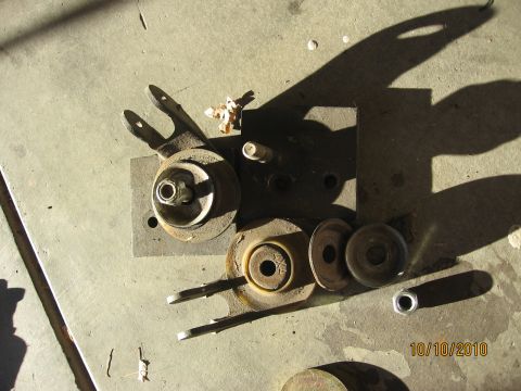 1994 Ford Bronco - Collection of old vehicle parts, possibly from a Ford Bronco, scattered on a concrete floor.