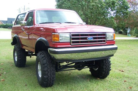 1990 Ford Bronco - This lifted 1990 Ford Bronco is presented with a prominent chrome grille and large off-road tires.
