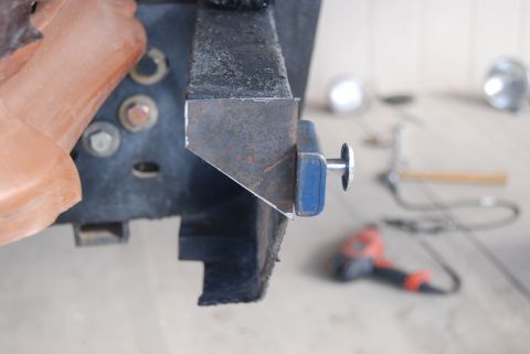 1982 Ford Bronco - A custom metal bracket is attached to a vehicle's frame, with a drill and other tools visible in the background.