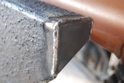 1982 Ford Bronco - Detail of a welded metal frame, possibly part of an automotive upgrade or repair, with visible weld marks and a textured surface.