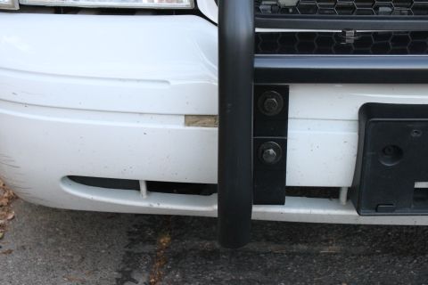 2003 Ford Crown Victoria - Front view of a white 2003 Ford Crown Victoria showing the bumper, grille, and an attached push bar.