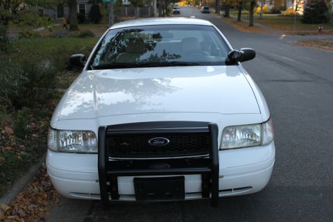 2003 Ford Crown Victoria - Front view of a white 2003 Ford Crown Victoria equipped with a push bar.
