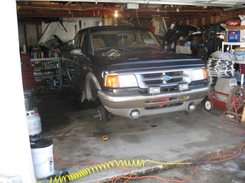 1995 Ford Ranger - 1995 Ford Ranger truck is parked in a garage with its front end raised on jack stands.