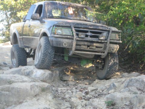 1995 Ford Ranger - A modified Ford Ranger truck is shown off-roading on a rocky trail.