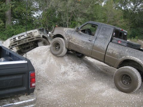 1995 Ford Ranger - Two trucks, including a 1995 Ford Ranger, navigate a challenging off-road course.