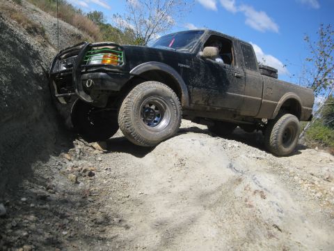 1995 Ford Ranger - A black Ford Ranger navigates a steep, rocky incline during an off-road excursion.