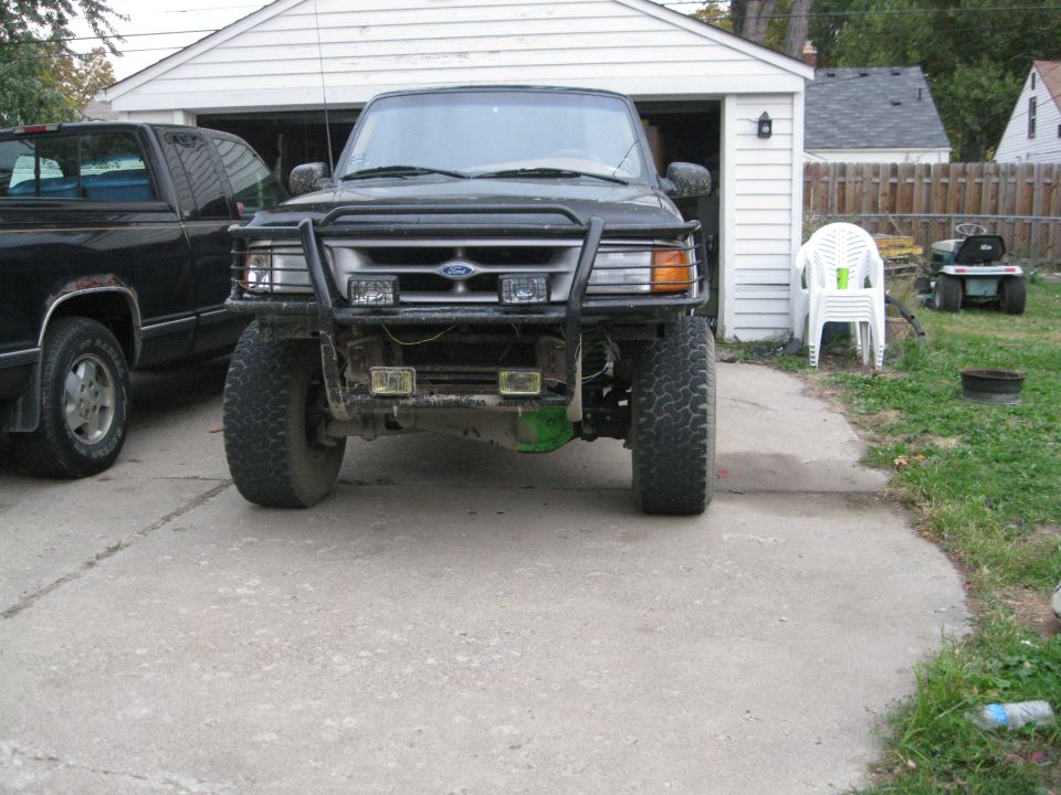 Black Ford Ranger with bull bar and off-road tires, parked in driveway