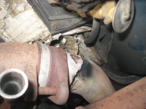 1976 Ford F-250 - Close-up view of a vehicle's exhaust system components, showing signs of wear and repair.