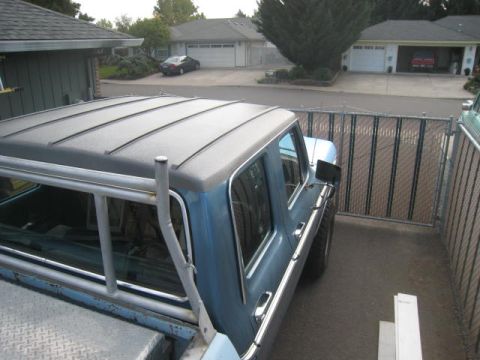 1976 Ford F-250 - A blue pickup truck is parked next to a chain-link fence in a residential driveway.