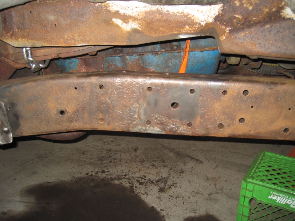 Rusty vehicle frame crossmember underbody with drilled mounting holes