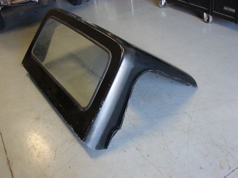 1993 Jeep YJ - A black Jeep hardtop is shown from the side, resting on a concrete floor.