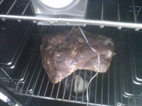 1986 Ford Bronco - Meat cooking inside an oven on metal racks.