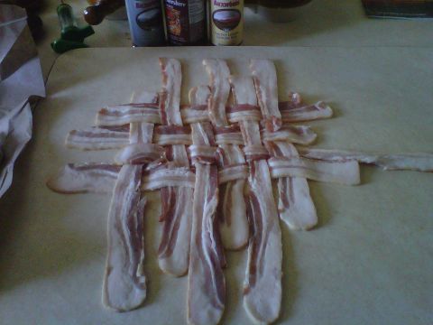 1986 Ford Bronco - Raw bacon is woven into a lattice pattern on a cutting board, with various spice containers visible behind it.