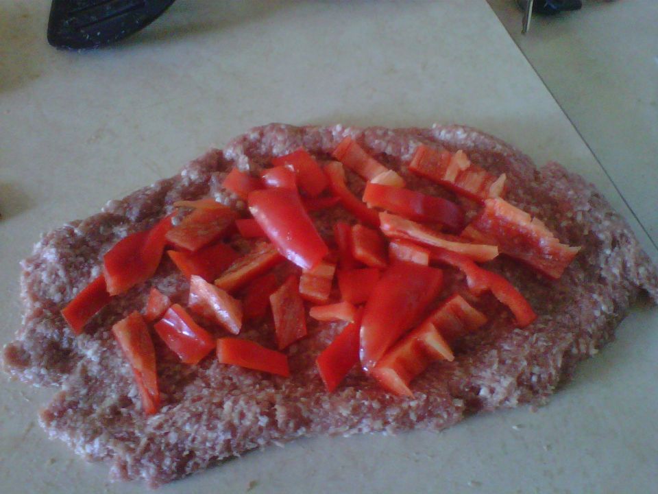 Ground meat topped with chopped red bell peppers