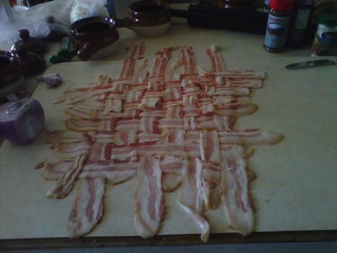 1986 Ford Bronco - Bacon woven into a mat on a cutting board, with kitchen items visible in the background.