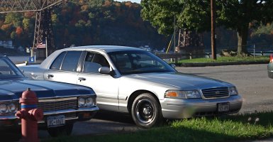 2000 Ford Crown Victoria - A silver sedan is parked on the side of the road next to another vehicle, with a fire hydrant visible.