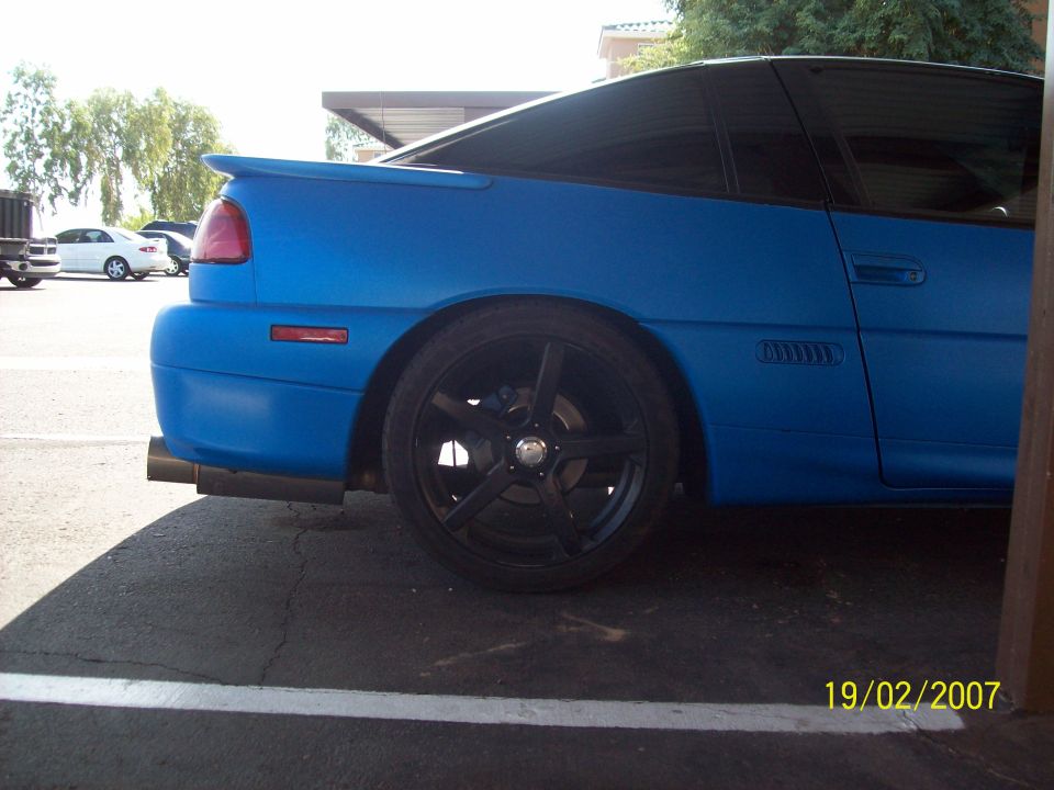 Blue sports coupe rear quarter panel and wheel. Date stamp reads 19/02/2007