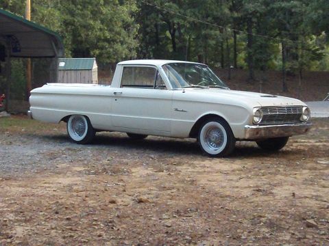 1963 Ford Ranchero - A white 1963 Ford Ranchero pickup truck is viewed from a three-quarter front angle, parked on a gravel surface.