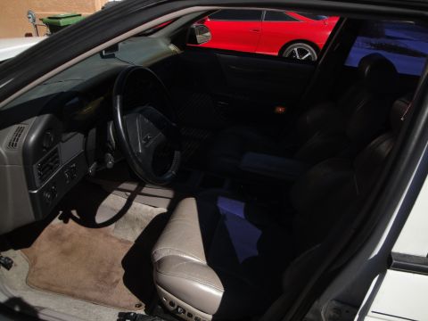 1989 Ford Taurus - The interior of a car is shown, with a red car visible through the window.