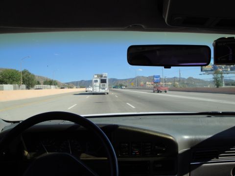 1989 Ford Taurus - Driving on a highway with a camper van and a red pickup truck ahead.