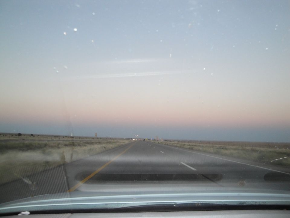 View of a highway stretching into the distance at dusk with a pastel sky