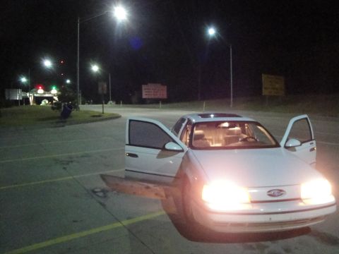 1989 Ford Taurus - 1989 Ford Taurus with doors open at night, illuminated by its headlights.