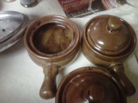 1986 Ford Bronco - Several brown ceramic crock pots are arranged on a surface, with one lid off.