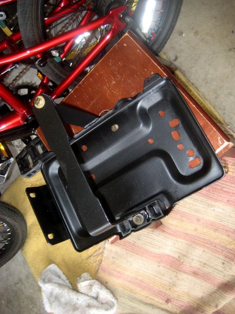 1996 Ford Bronco - A black metal bracket with red accents and a lever arm is shown from a top-down perspective.